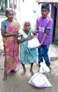 Periyakka receiving hope for the elderly rationing kits from a Hope student