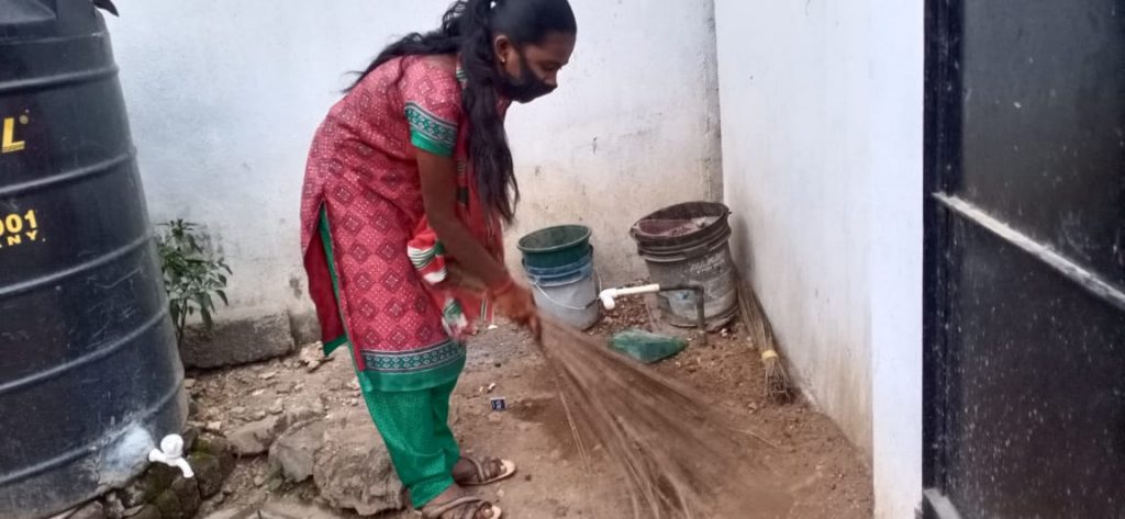 Hope Student Yazhini sweeping her backyard.